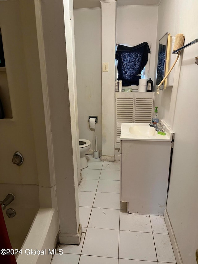 bathroom featuring a washtub, vanity, tile patterned flooring, and toilet