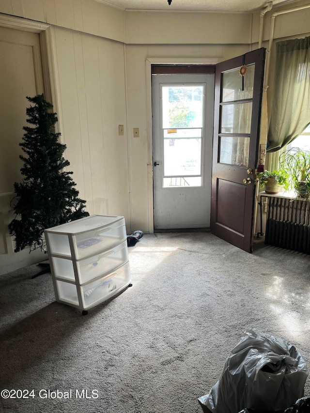 doorway with carpet floors and radiator heating unit