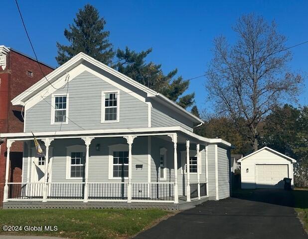 view of front of house with a garage, an outbuilding, and a porch