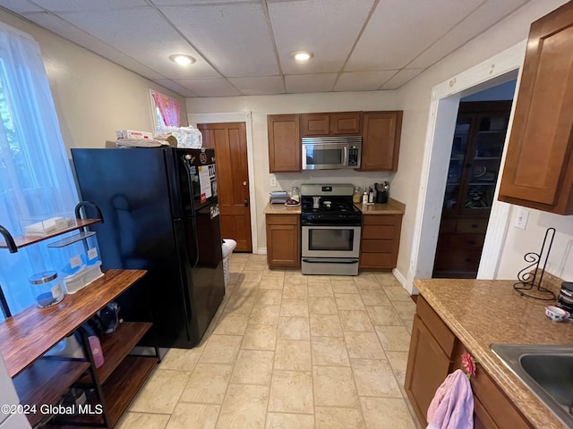 kitchen featuring sink, a drop ceiling, and stainless steel appliances