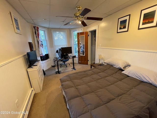 bedroom featuring ceiling fan, light carpet, and a baseboard heating unit