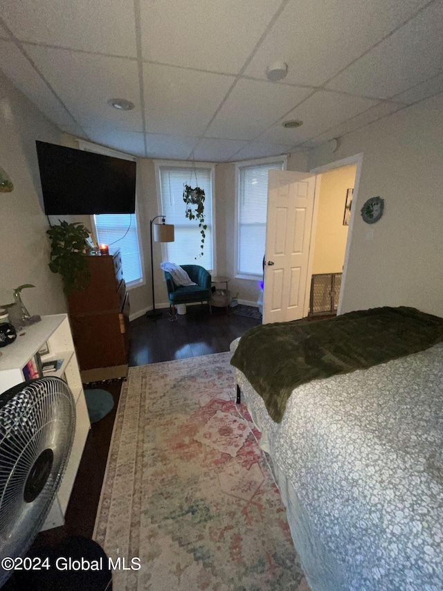 bedroom featuring a paneled ceiling and hardwood / wood-style floors