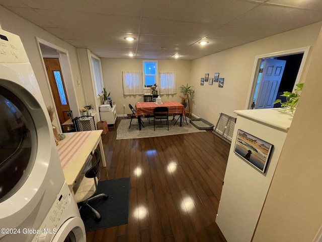 interior space featuring stacked washer and clothes dryer and dark wood-type flooring