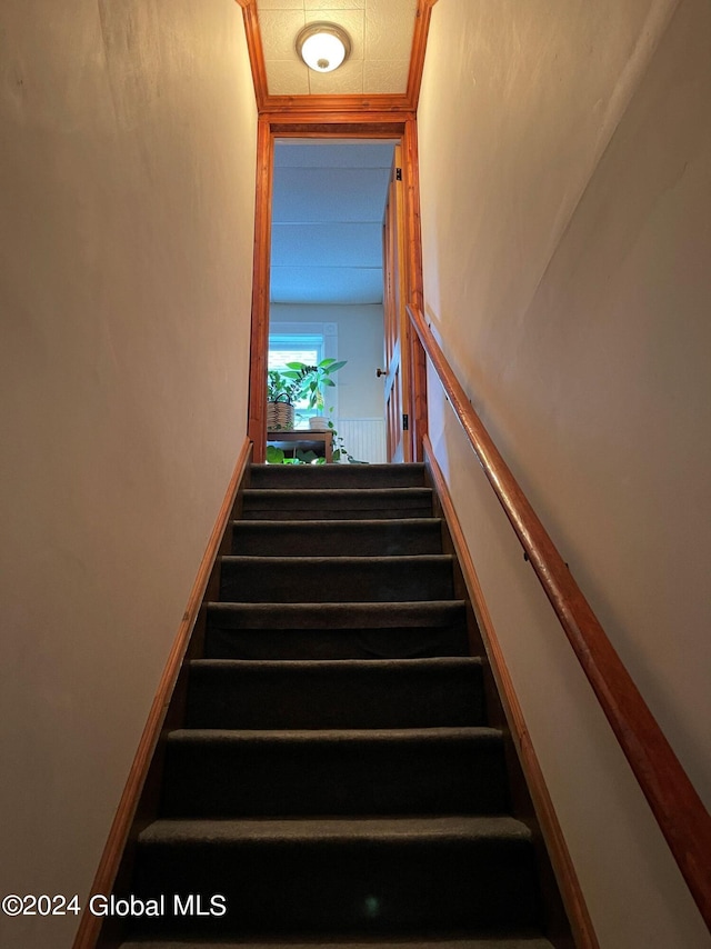 staircase featuring ornamental molding