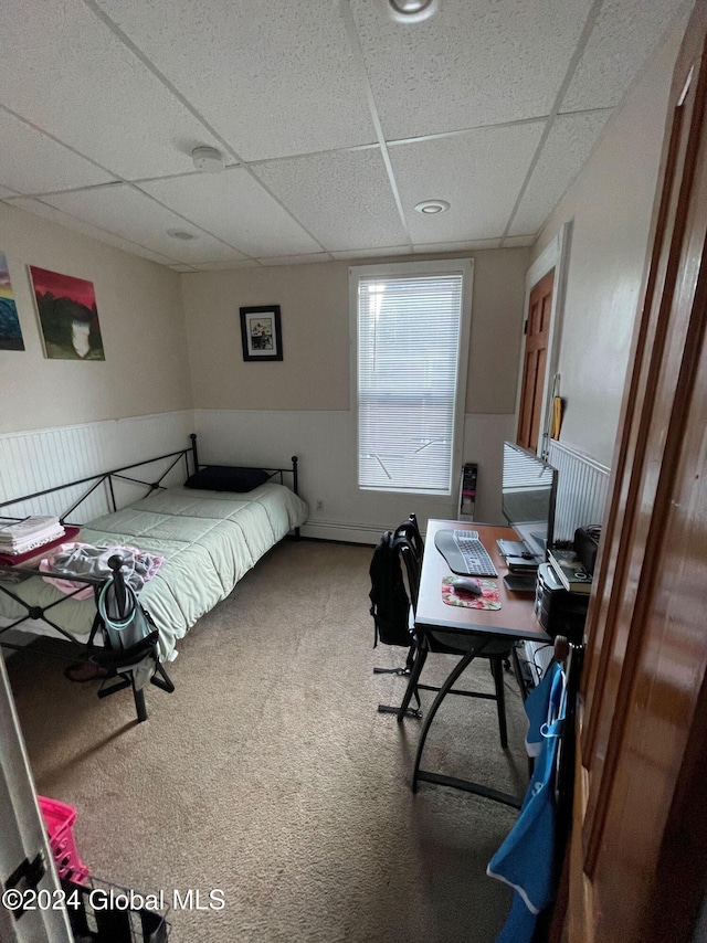 bedroom featuring a drop ceiling and carpet floors