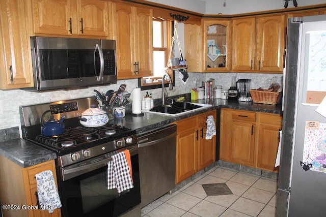 kitchen with light tile patterned floors, stainless steel appliances, sink, and tasteful backsplash