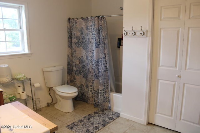 bathroom with tile patterned floors, toilet, and shower / bathtub combination with curtain