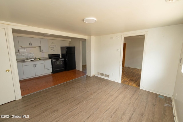 kitchen featuring sink, backsplash, black appliances, and light hardwood / wood-style floors