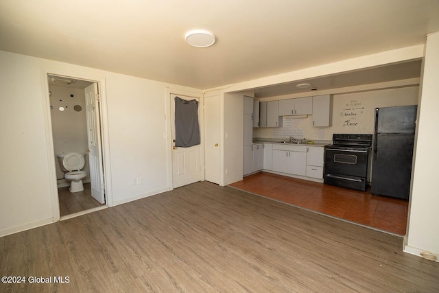 kitchen with tasteful backsplash, black appliances, sink, dark hardwood / wood-style flooring, and gray cabinets