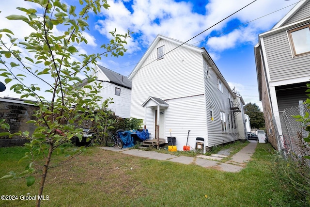 rear view of property featuring a yard