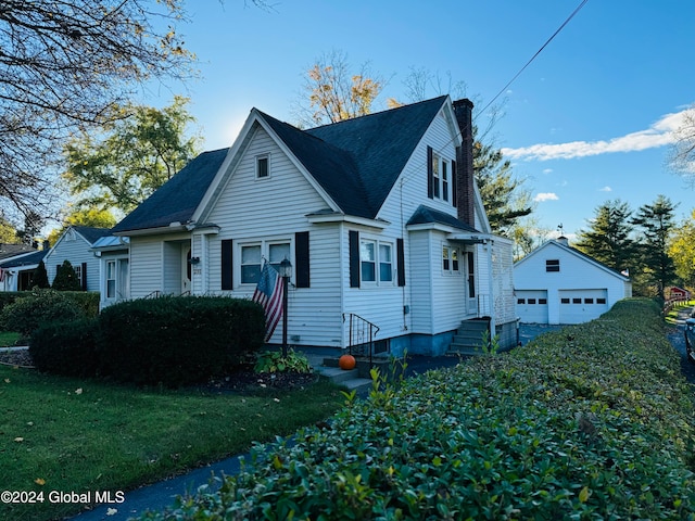 view of side of home featuring a yard, a garage, and an outbuilding