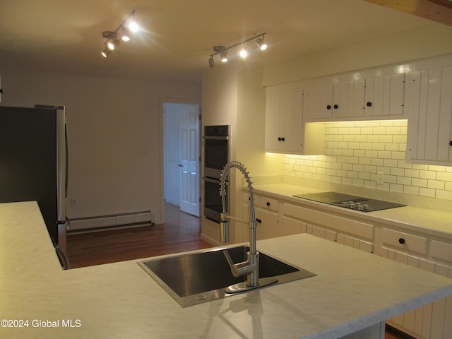 kitchen featuring baseboard heating, dark wood-type flooring, stainless steel appliances, sink, and white cabinets