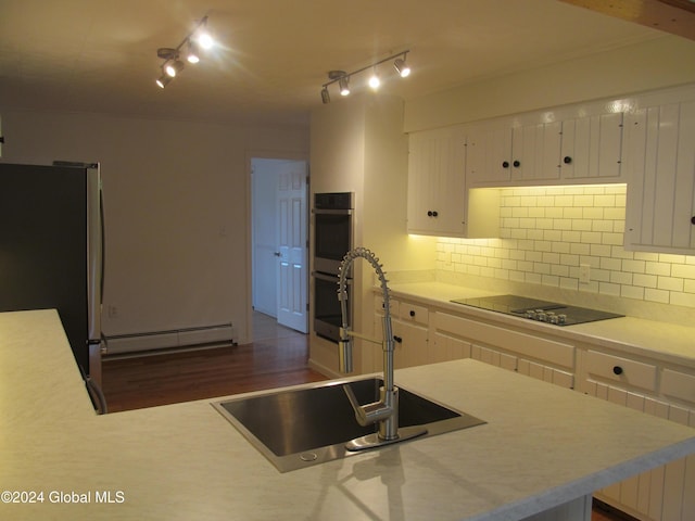kitchen featuring a baseboard radiator, appliances with stainless steel finishes, a sink, and light countertops