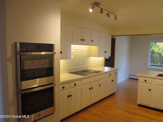 kitchen with white cabinets, baseboard heating, black electric cooktop, light hardwood / wood-style floors, and double oven