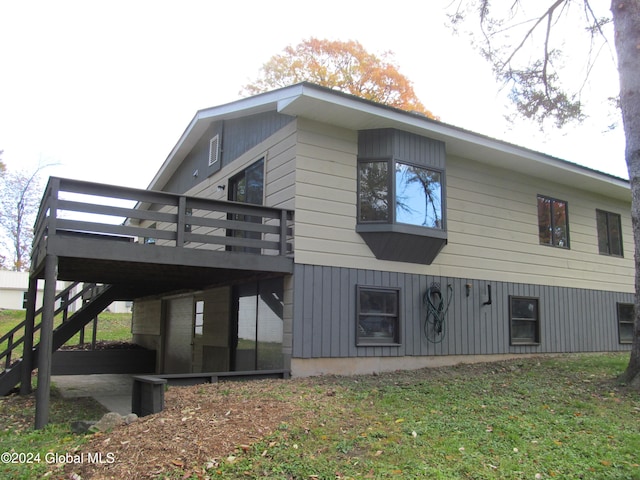 view of side of home featuring a wooden deck and a yard