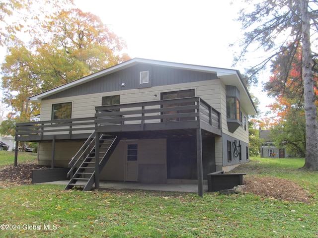 back of property with a yard and a deck