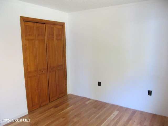 unfurnished bedroom with a closet and light wood-type flooring