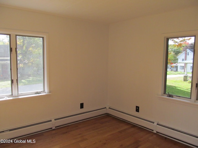 spare room with a healthy amount of sunlight and dark hardwood / wood-style floors