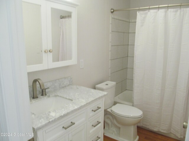 full bathroom with vanity, shower / bath combo, toilet, and wood-type flooring