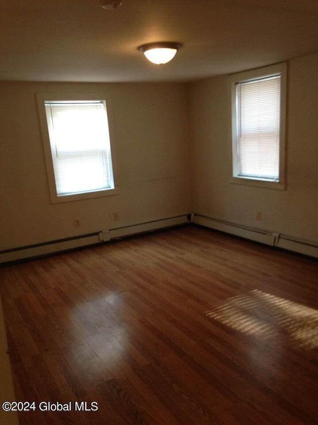 unfurnished room with dark hardwood / wood-style floors and plenty of natural light