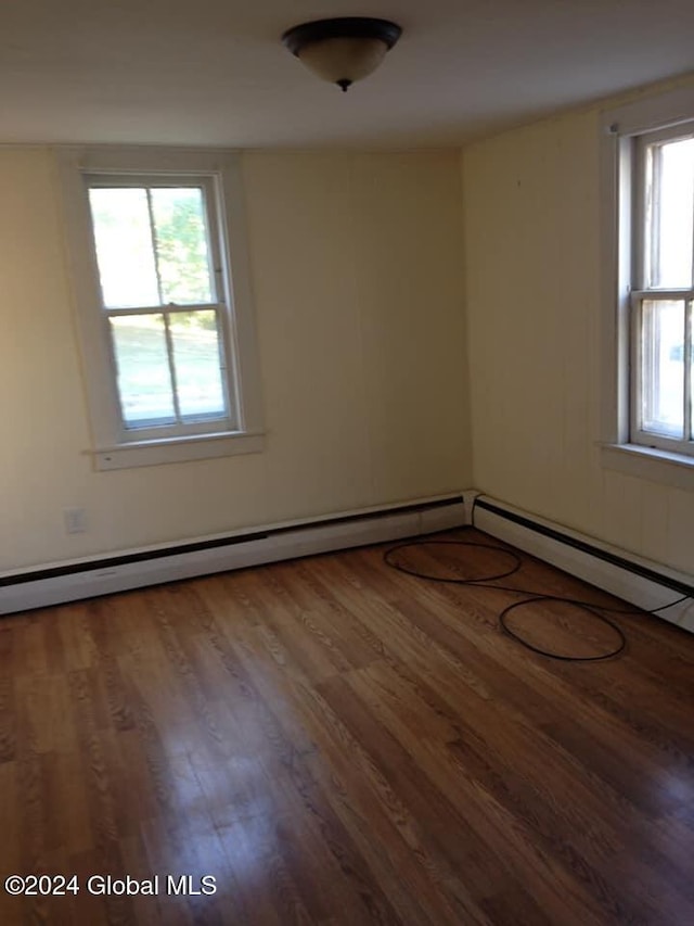 empty room with hardwood / wood-style flooring and a wealth of natural light