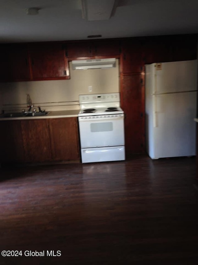 kitchen with white appliances, dark wood-type flooring, and sink