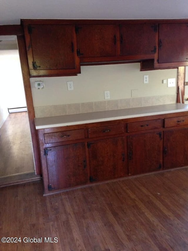 kitchen with dark hardwood / wood-style flooring and a baseboard heating unit