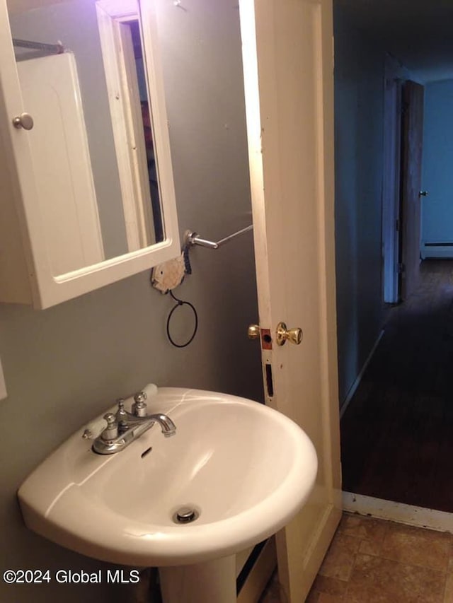 bathroom with sink and a baseboard heating unit