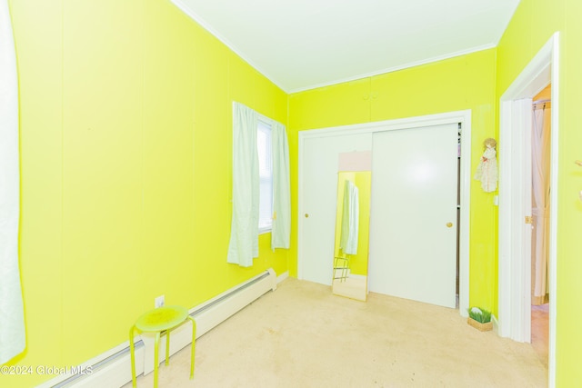 carpeted spare room with crown molding and a baseboard heating unit