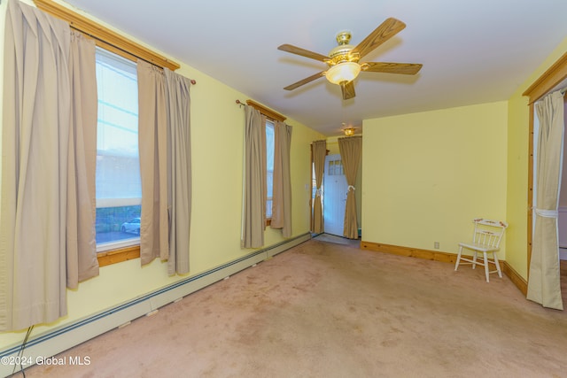 carpeted empty room featuring a baseboard heating unit and ceiling fan