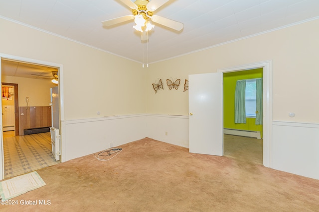 empty room with ornamental molding, baseboard heating, and carpet flooring