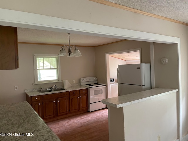 kitchen featuring white appliances, sink, a notable chandelier, decorative light fixtures, and light hardwood / wood-style floors