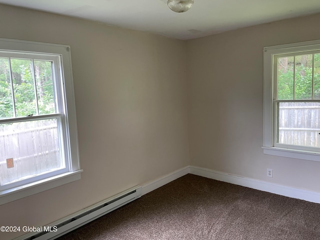 empty room featuring carpet flooring, a baseboard radiator, and a wealth of natural light