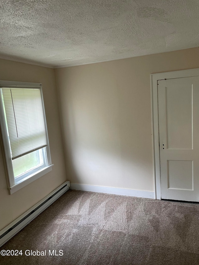 spare room featuring a textured ceiling, carpet, and a baseboard radiator