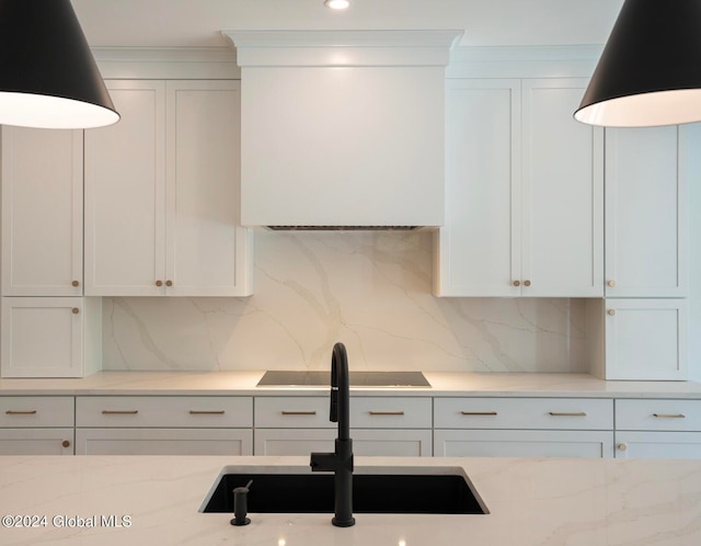 kitchen featuring tasteful backsplash, sink, and white cabinets