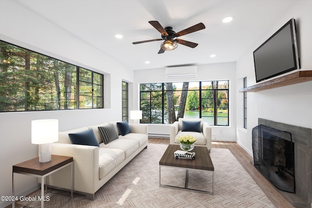 living room with light wood-type flooring, a wall unit AC, ceiling fan, and a healthy amount of sunlight