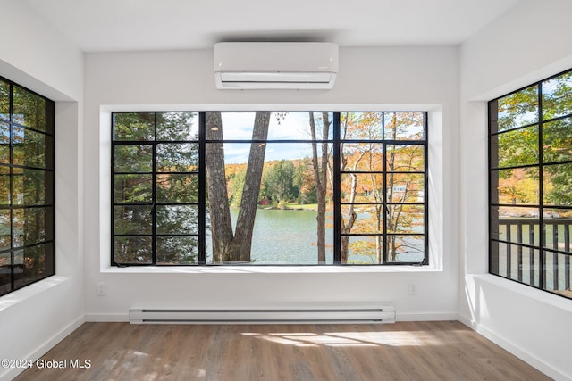 interior space with a water view, an AC wall unit, and a baseboard radiator