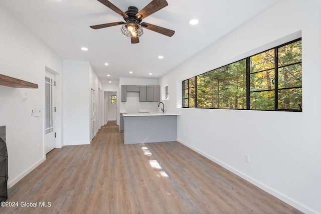 unfurnished living room featuring ceiling fan and light hardwood / wood-style flooring