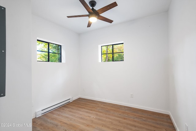 unfurnished room featuring baseboard heating, ceiling fan, and light hardwood / wood-style floors