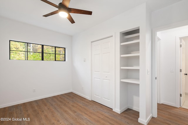 unfurnished bedroom featuring ceiling fan, a closet, and wood-type flooring