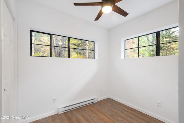 unfurnished room featuring a healthy amount of sunlight, ceiling fan, a baseboard radiator, and wood-type flooring