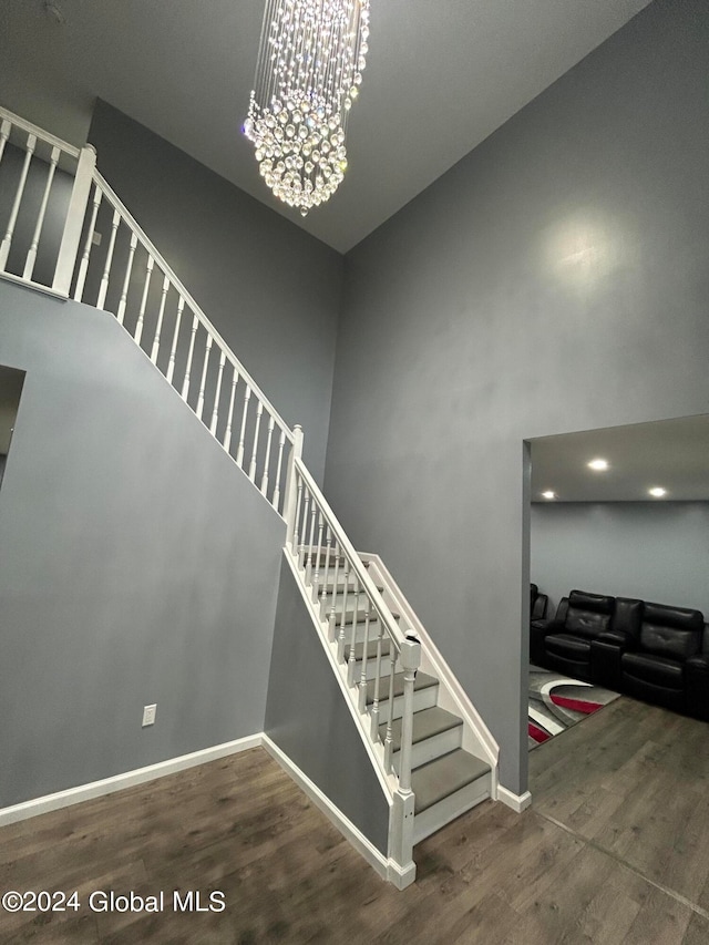 stairs with hardwood / wood-style flooring and a towering ceiling