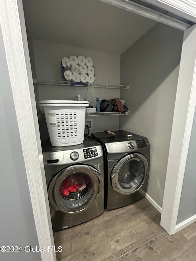 laundry area featuring light hardwood / wood-style floors and washer and clothes dryer