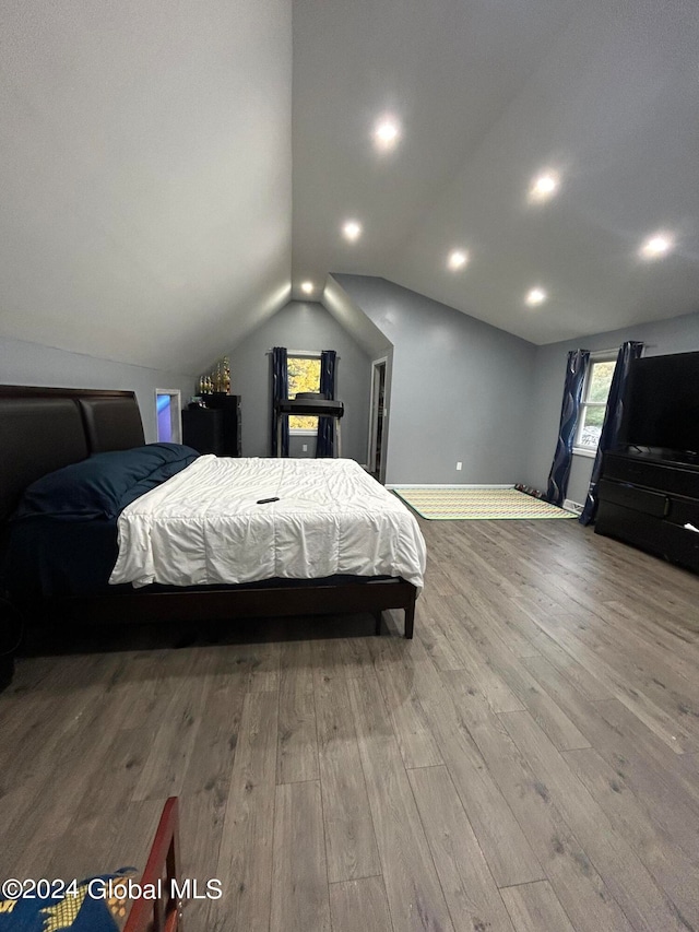 bedroom featuring hardwood / wood-style flooring and lofted ceiling