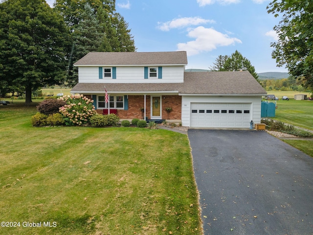 view of property featuring a garage and a front lawn