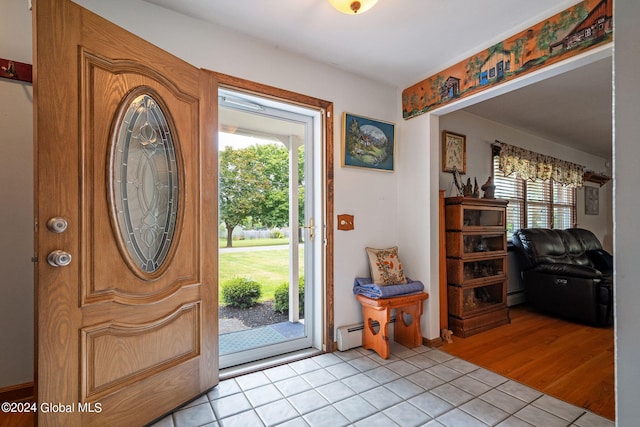 foyer with a baseboard heating unit and light wood-type flooring