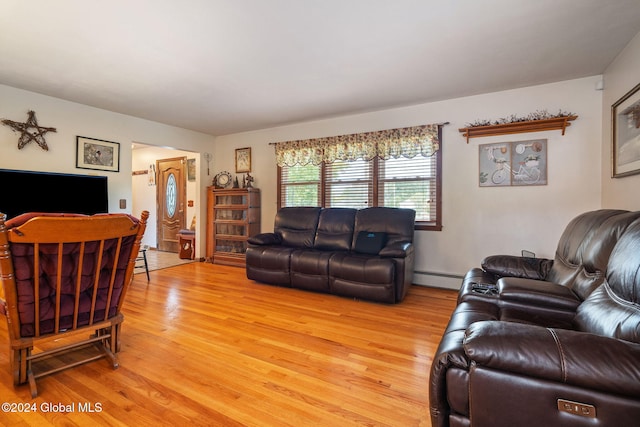 living room with baseboard heating and light hardwood / wood-style flooring