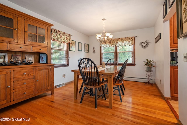 dining space with an inviting chandelier, a baseboard radiator, and light wood-type flooring