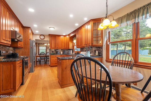 kitchen with a healthy amount of sunlight, a notable chandelier, and stainless steel fridge