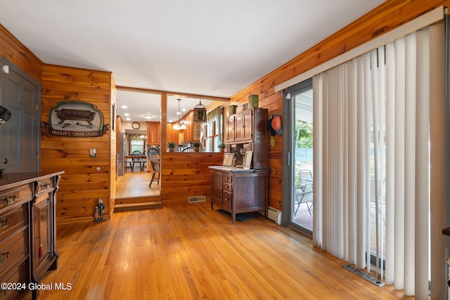 interior space with a baseboard radiator, wooden walls, and light wood-type flooring